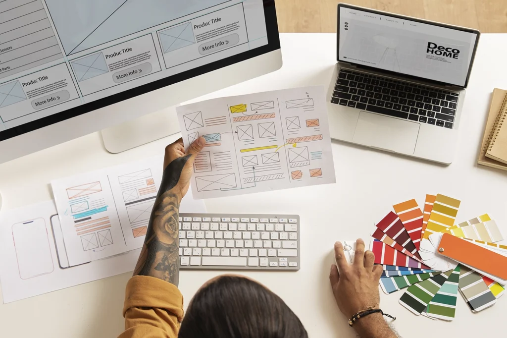 Weboldal dizájntervezés folyamatban: wireframe-ek, színpaletták és webes vázlatok egy asztalon